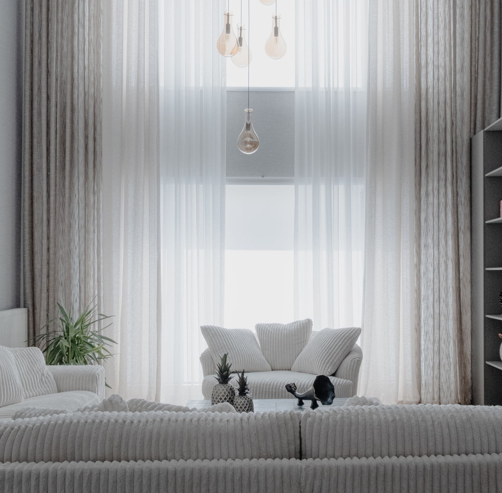 Bright, neutral living room with soft furnishings and sheer curtains