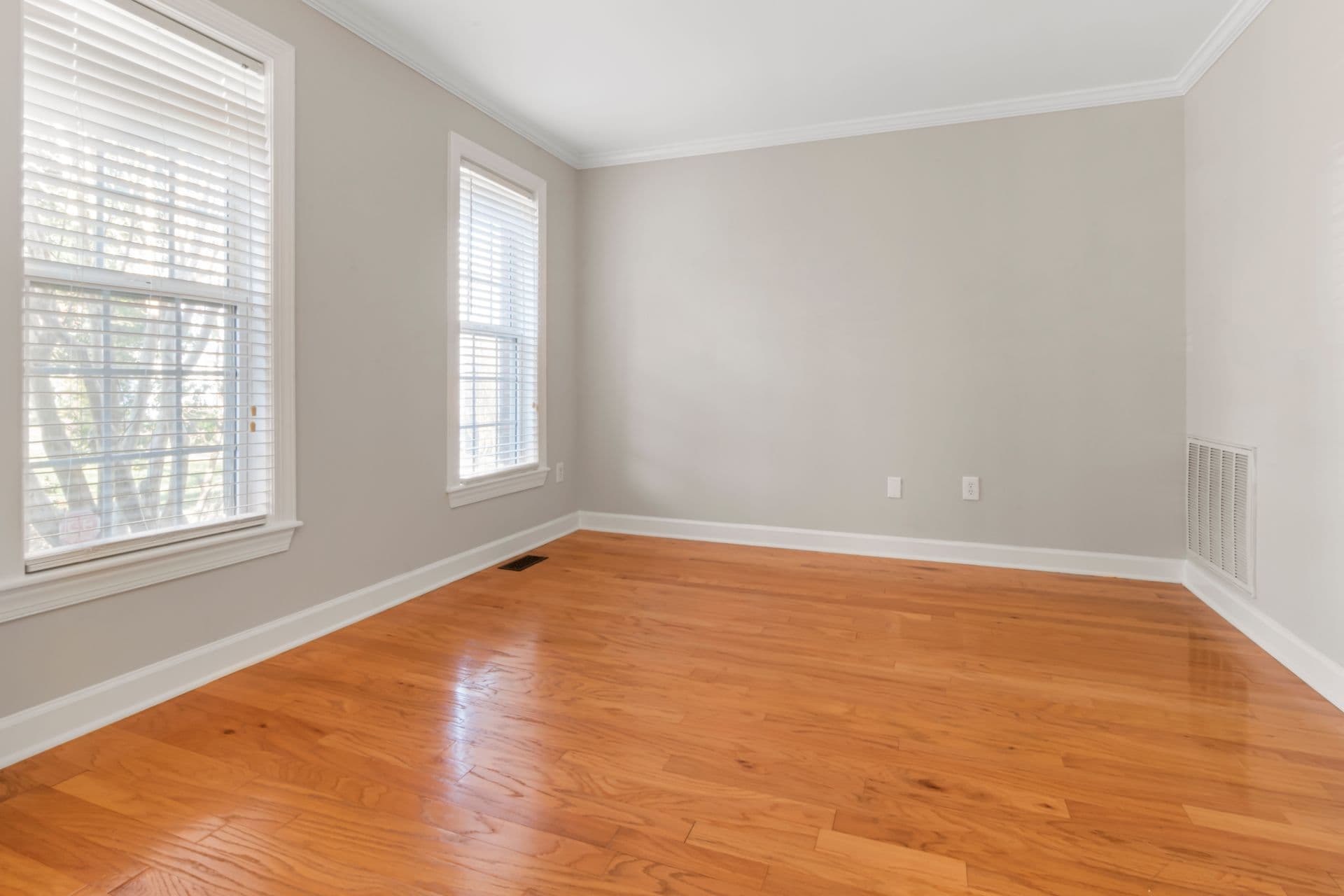 Restored hardwood flooring and refinished interior in a bright, empty room