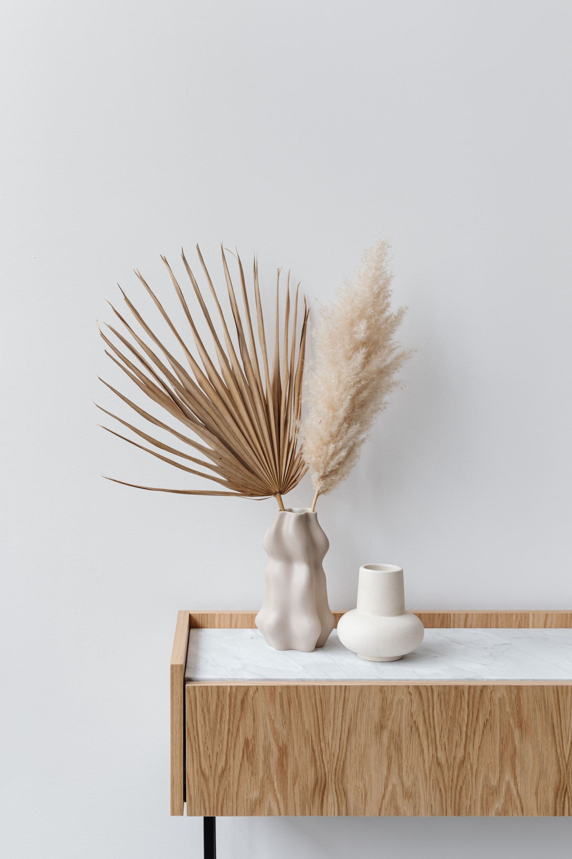 Styled console table with dried palm and pampas grass in ceramic vases